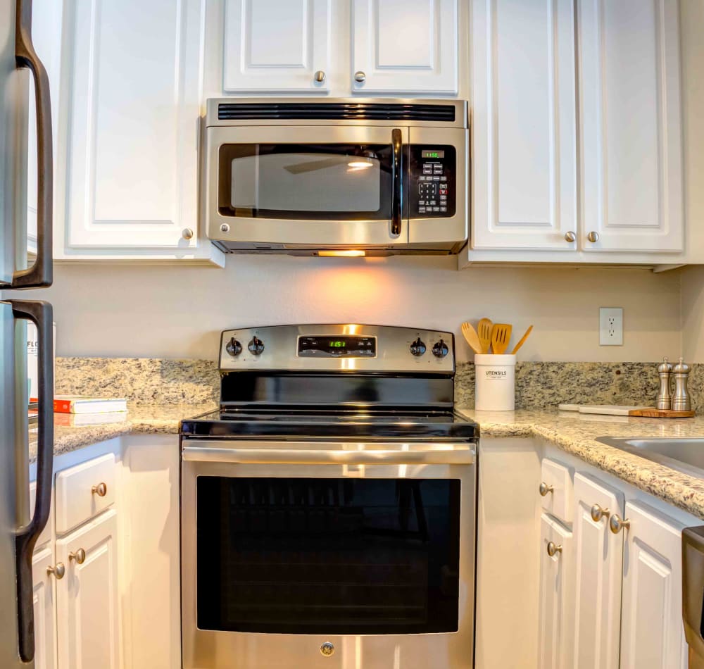 Modern kitchen with sleek, stainless-steel appliances and bright white cabinetry in a model home at Sofi Berryessa in San Jose, California