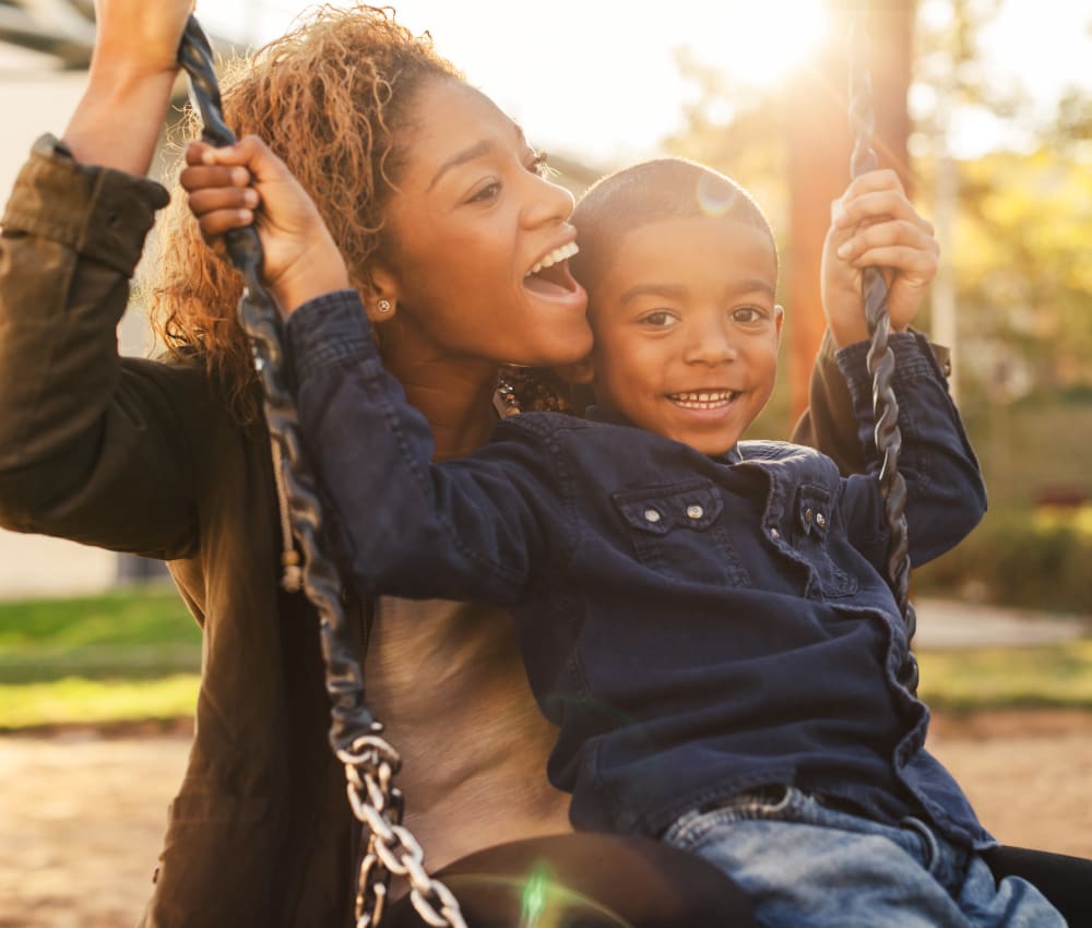 Mother and son on the swings at The Columns at Club Drive in Duluth, Georgia