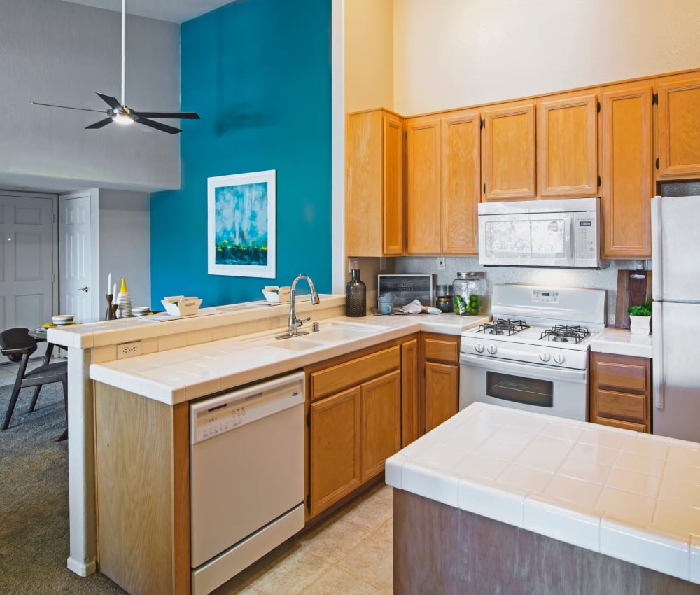 Modern kitchen with subway tile countertops and stainless-steel appliances in a model home at Sofi Canyon Hills in San Diego, California