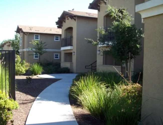Charming pathway leading to modern residences amidst lush landscaping at Sommerset Place in Sacramento, California.
