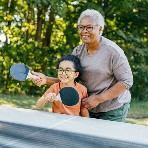 Resident playing ping pong with her granddaughter at Oxford Vista Wichita in Wichita, Kansas