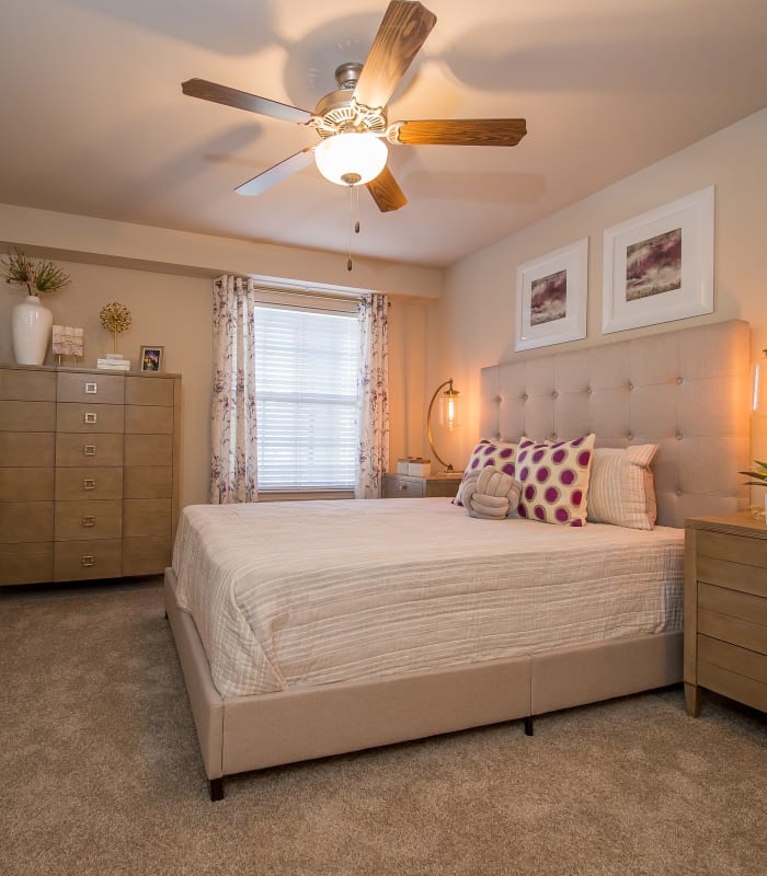 Chic bedroom with ceiling fan at Watercress Apartments in Maize, Kansas