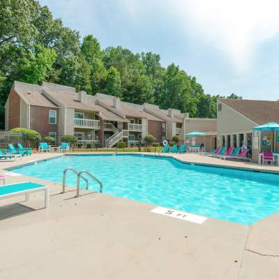 Beautiful blue Swimming Pool with Chaise Lounges at Devonwood Apartment Homes in Charlotte, North Carolina