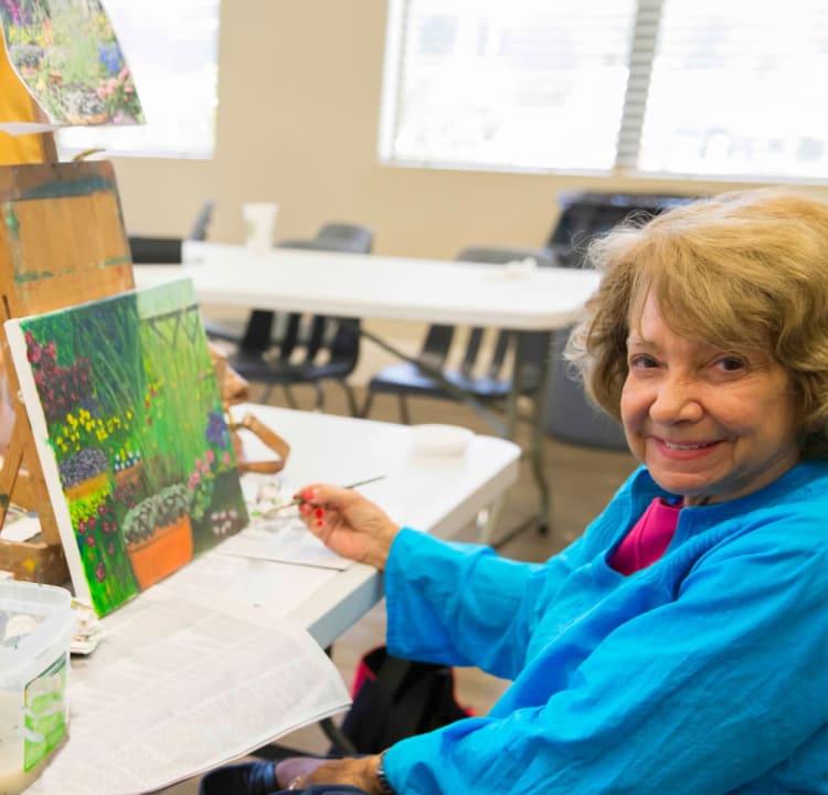 Senior woman painting on canvas at Azpira Place of Breton in Kentwood, Michigan