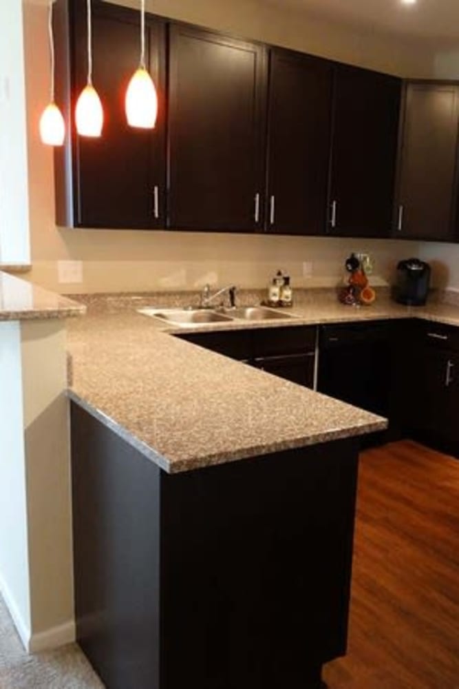 Kitchen with modern counters and wood style flooring at Oak Grove Crossing Apartments in Newburgh, Indiana