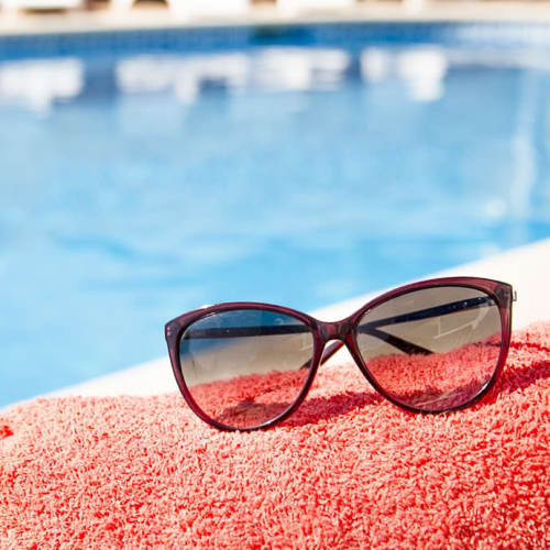 Sunglasses and towel next to pool at Legacy at Cypress in Cypress, Texas