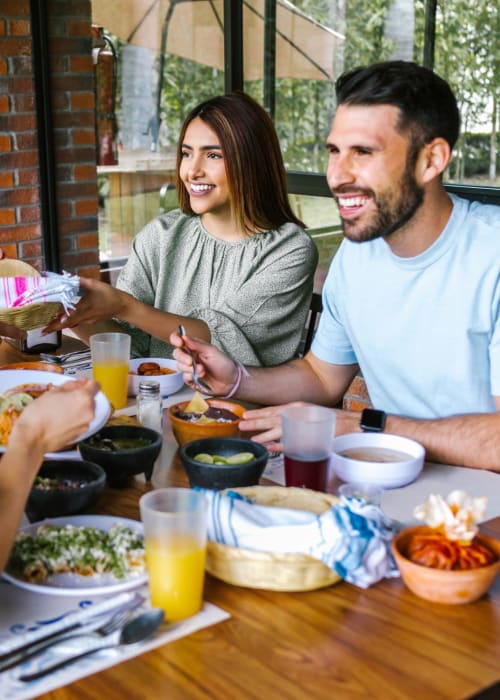 Group of friend dining outdoors near The Fredd Townhomes in San Antonio, Texas