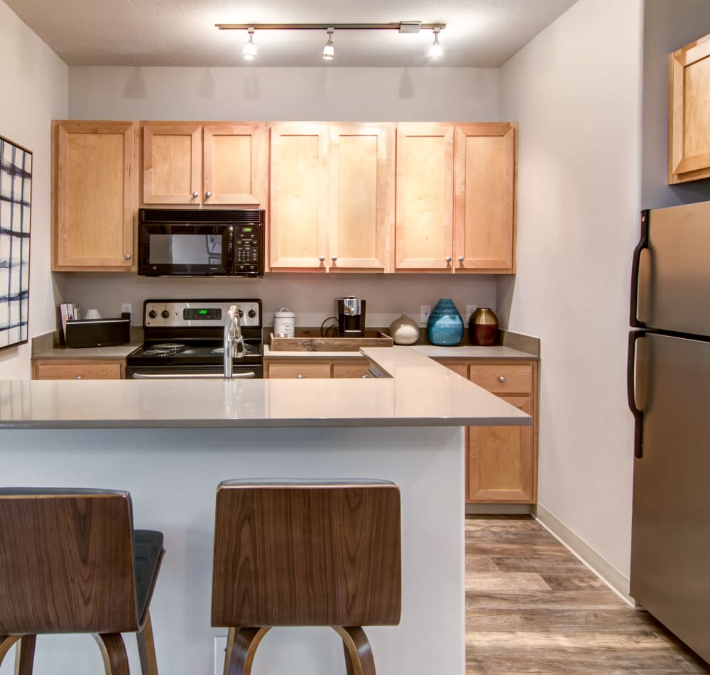 Quartz countertop and stainless-steel appliances in a model home's kitchen at Sofi at Forest Heights in Portland, Oregon