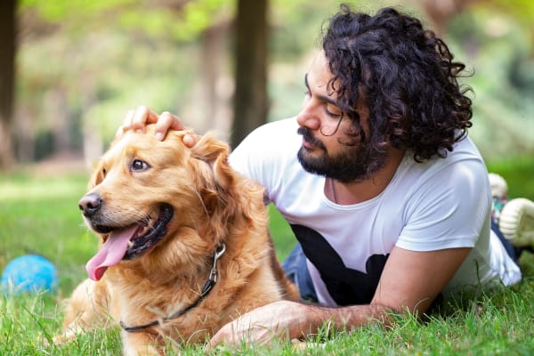 Man and his dog laying in green grass at The Flats at Lancaster in Clarksville, Tennessee