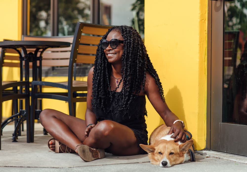 Woman petting her dog on the ground outside of Motif in Fort Lauderdale, Florida