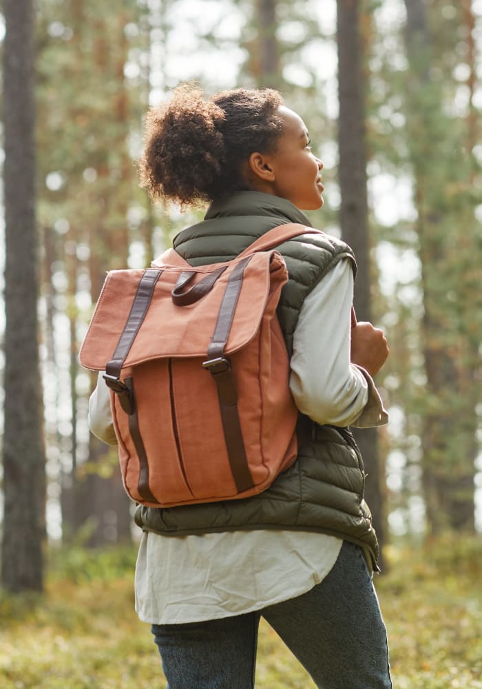 A woman with a backpack hiking in a forest near Stonecreek Club in Germantown, Maryland