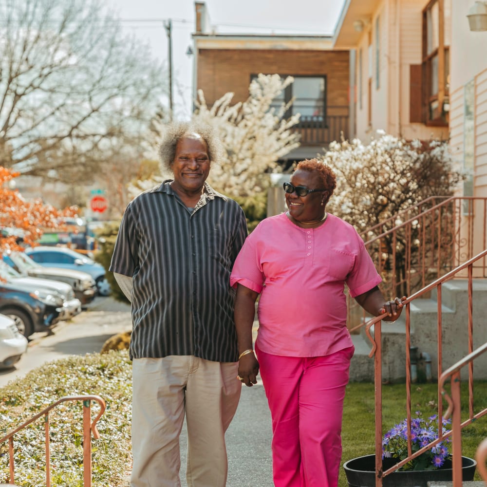 Caregiver and resident enjoying a walk outside at a community by Cascade Senior Living Services