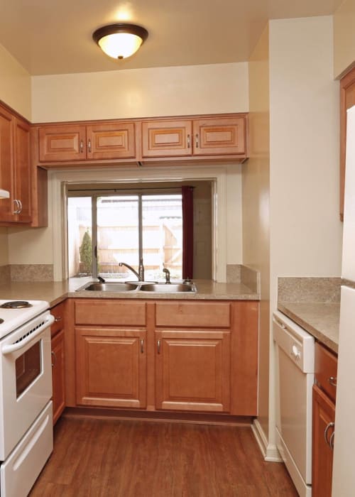 Kitchen with white appliances and double stainless-steel sink at River Oaks in Pittsburgh, Pennsylvania