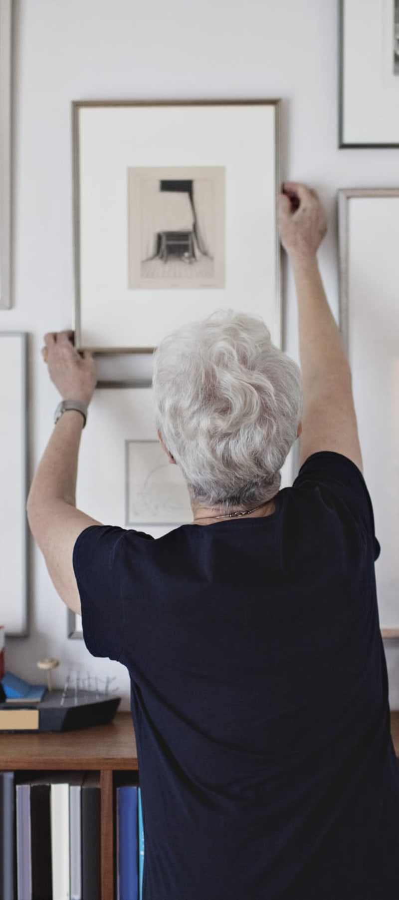 Resident hanging up a framed picture in their home at a WISH community