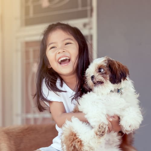 A happy girl holding her dog Wood Road in Annapolis, Maryland