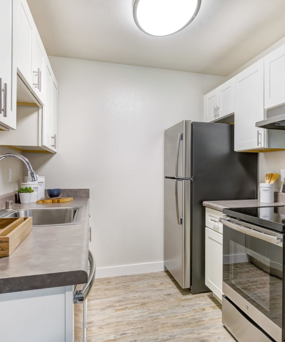 Modern kitchen with hardwood flooring and stainless-steel appliances in a model home at Sofi Union City in Union City, California