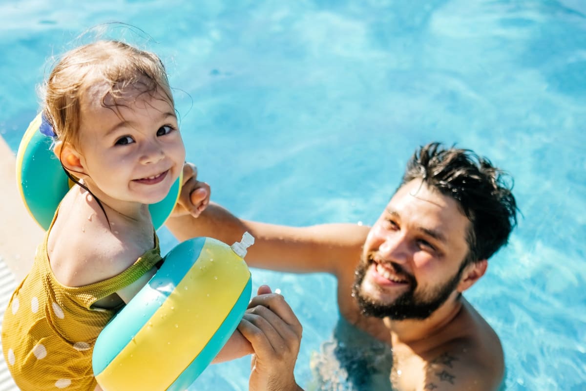 Father and child swimming at Vintage at 18th Street in Houston, Texas