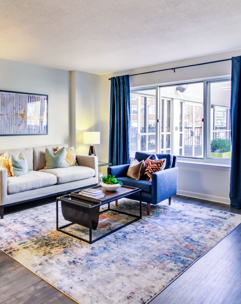 Naturally lit living room with  large bay windows in a model home's living area at Sofi at 50 Forest in Stamford, Connecticut