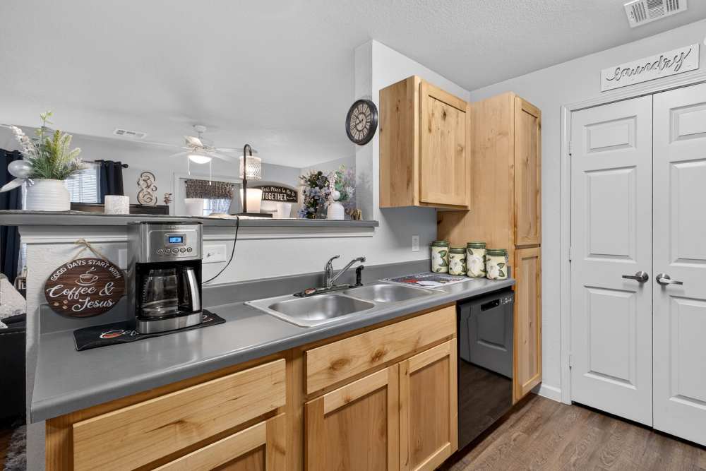 Modern kitchen with natural wood cabinetry and stainless steel appliances at Lakewood Crossing in Granbury, Texas.