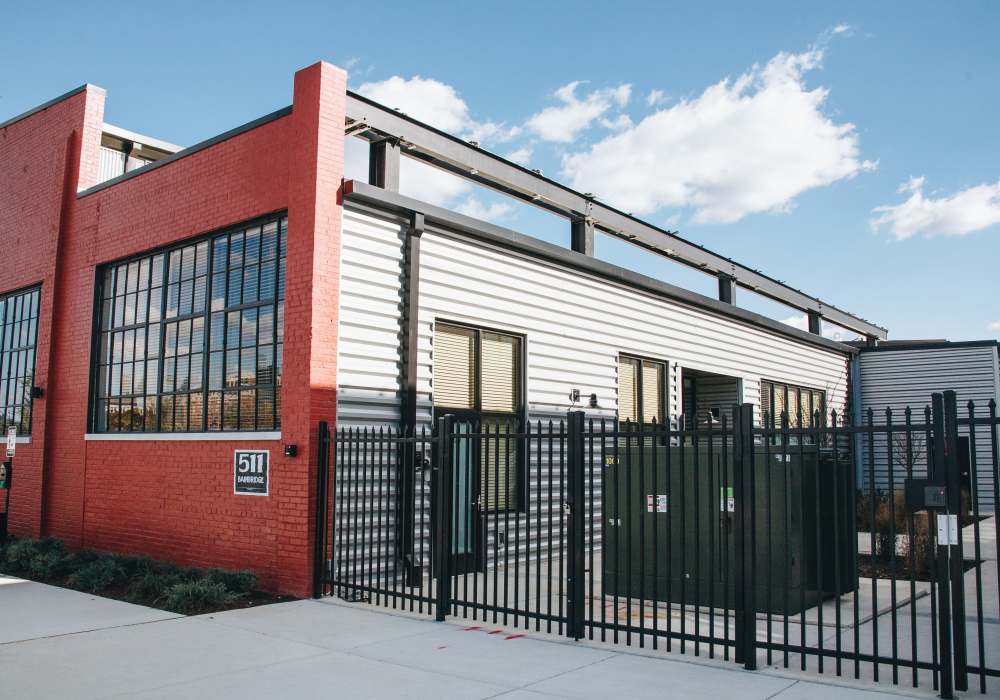 Exterior view of modern commercial building with red accent wall and glass doors at City View Lofts in Richmond, Virginia