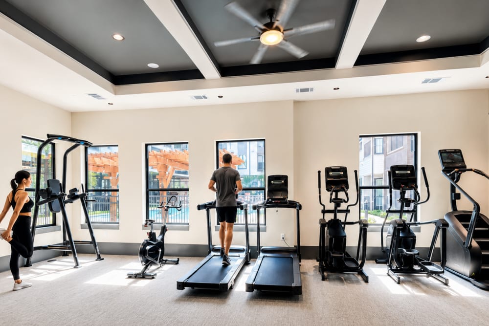 Residents work out at the fitness center overlooking the pool.