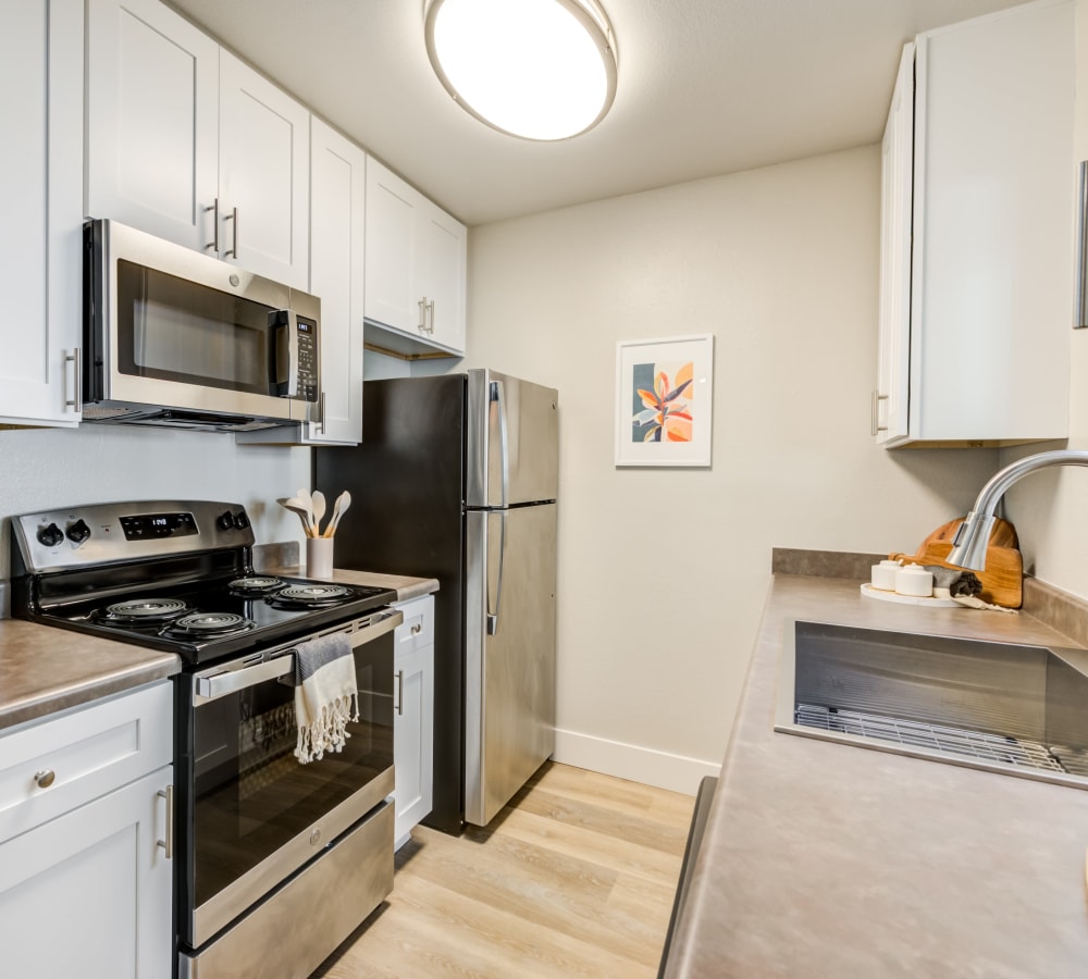 Stainless steel appliances such as microwave, oven, and fridge in an updated kitchen at The Landing at Channel Islands in Oxnard, California