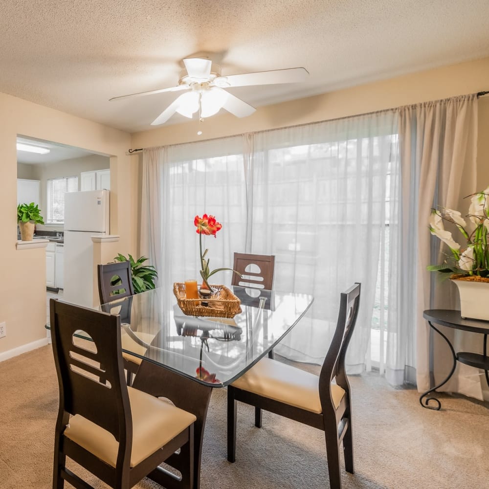 Dining area with a ceiling fan and sliding door access to a private patio at Park at Northside Apartments & Townhomes in Macon, Georgia