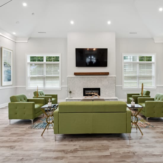 Resident lounge with a fireplace and flatscreen TV at The Villages at West Laurel in Richmond, Virginia