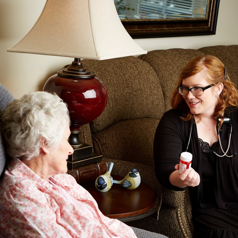 Resident sitting on a couch talking to a nurse at Deer Crest Senior Living in Red Wing, Minnesota