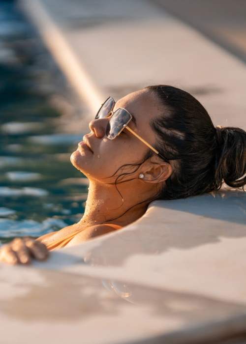 Woman relaxing in the swimming pool at The Pearl at Midtown in Dallas, Texas