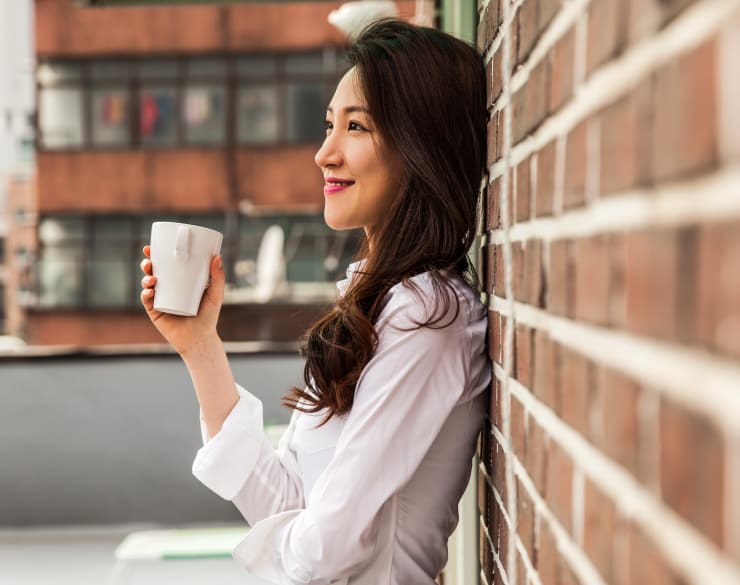 Woman leaning against the wall at Station House Apartments in Redmond, Washington