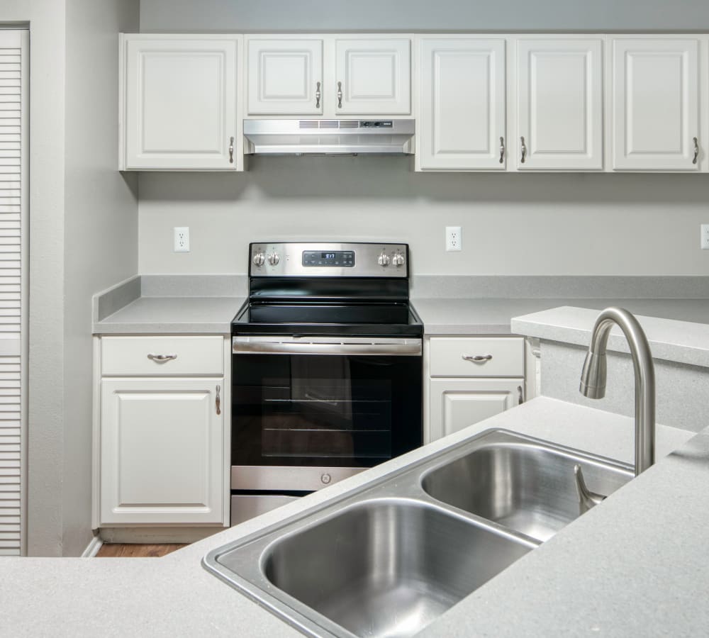 White cabinets and stainless steel appliances in a model kitchen at Mode at Ballast Point in Tampa, Florida