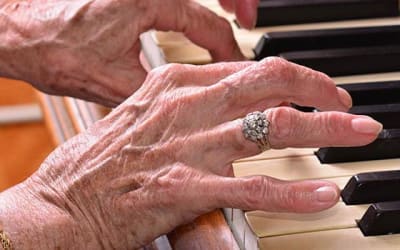 Resident playing piano at Mattison Crossing at Manalapan Avenue