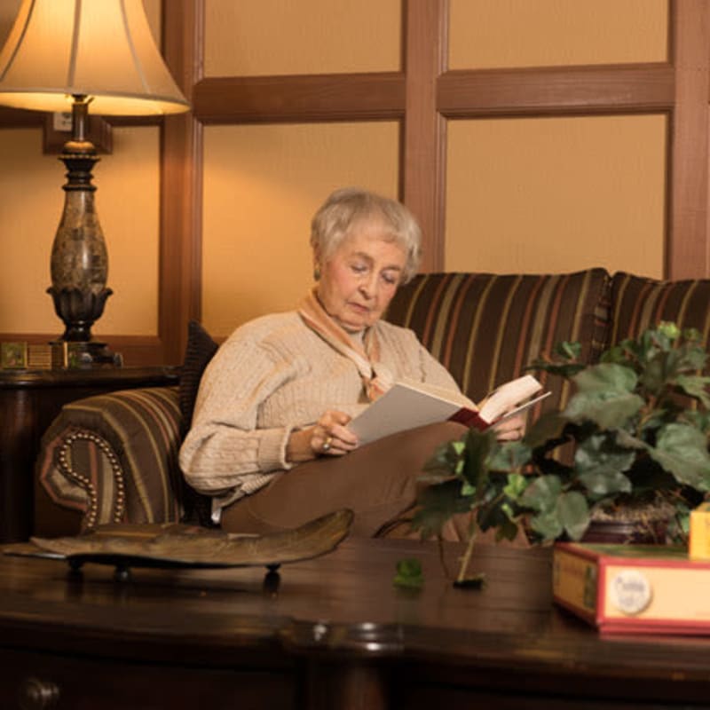 Assisted Living resident reading a book at York Gardens in Edina, Minnesota