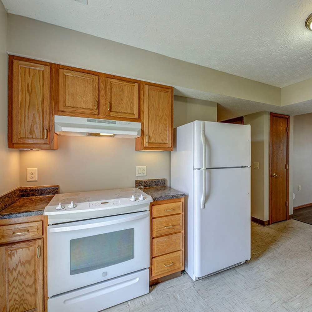 White refrigerator next to wooden cabinets at Orchard Glen in Orrville, Ohio