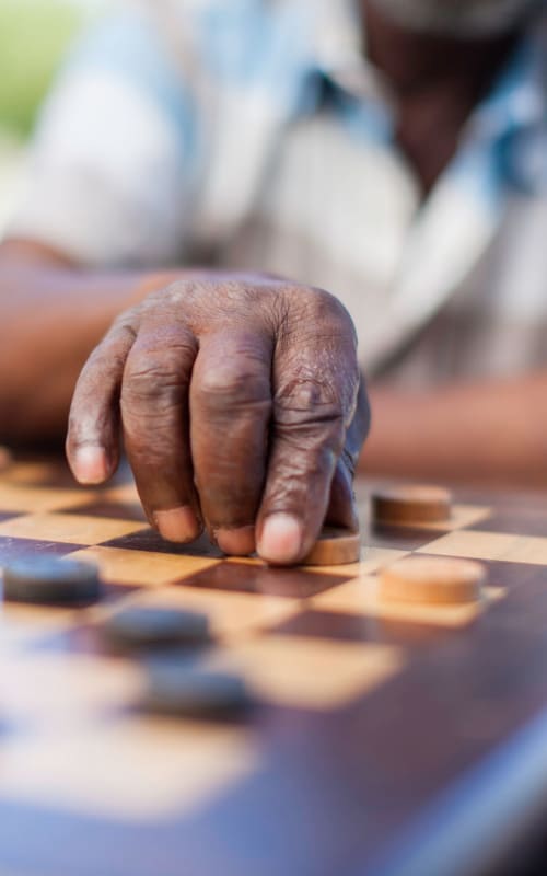 A close-up view of a hand on a chess board at The Pillars of Prospect Park in Minneapolis, Minnesota