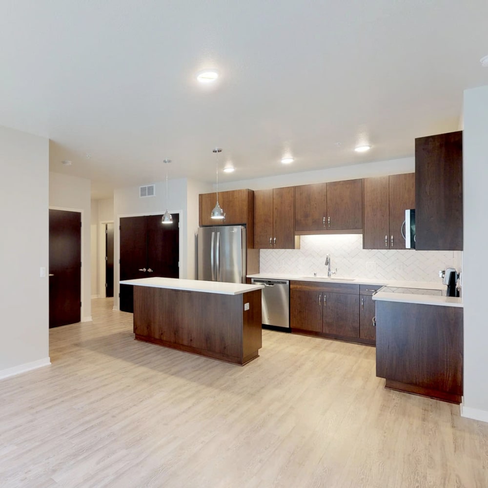 Beautiful hardwood floors and a chef-inspired kitchen in an open-concept model apartment at Oaks Union Depot in St Paul, Minnesota