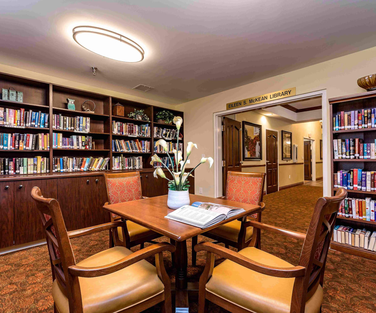 Elegant reading area with bookshelves and table seating at Pacifica Senior Living Skylyn in Spartanburg, South Carolina