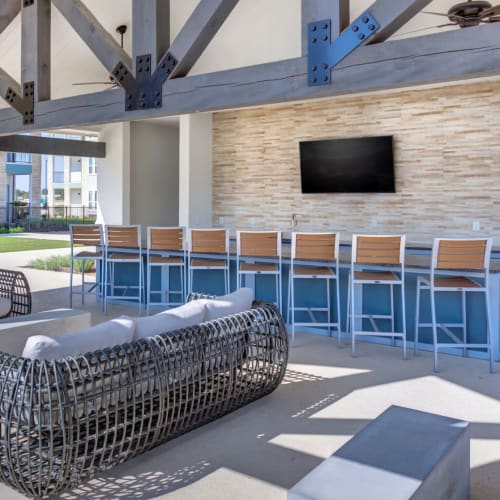Outdoor bar seating and TV by the swimming pool at Williamson at the Overlook in Georgetown, Texas