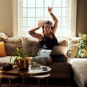 Resident listening to music and dancing in the living room of her new home at Willow Glen in Fort Worth, Texas