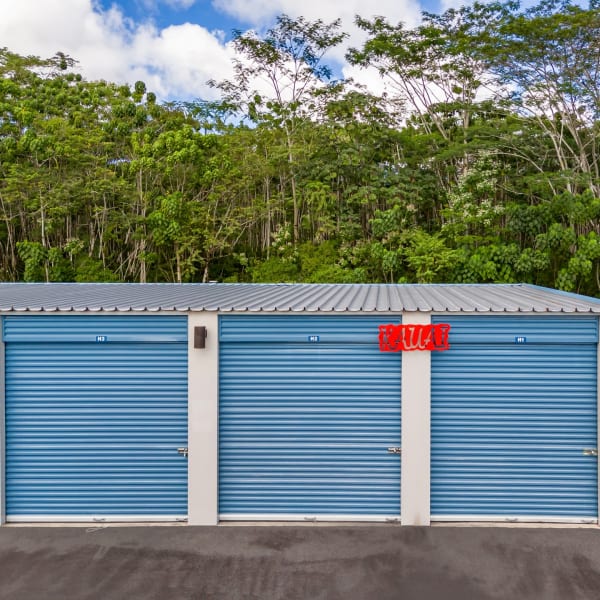 Large outdoor storage units with blue doors at StorQuest Self Storage in Kea'au, Hawaii