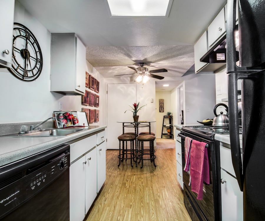 Kitchen with sleek black appliances and granite-style countertops in a model home at Santana Ridge in Denver, Colorado