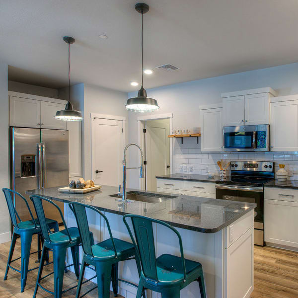 Gourmet kitchen with granite countertops and hardwood floors in model home at District Lofts in Gilbert, Arizona