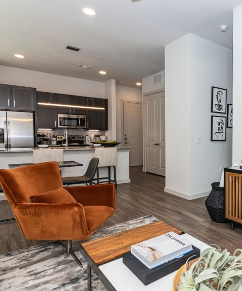Living room with wood-style flooring at Magnolia on the Green in Allen, Texas