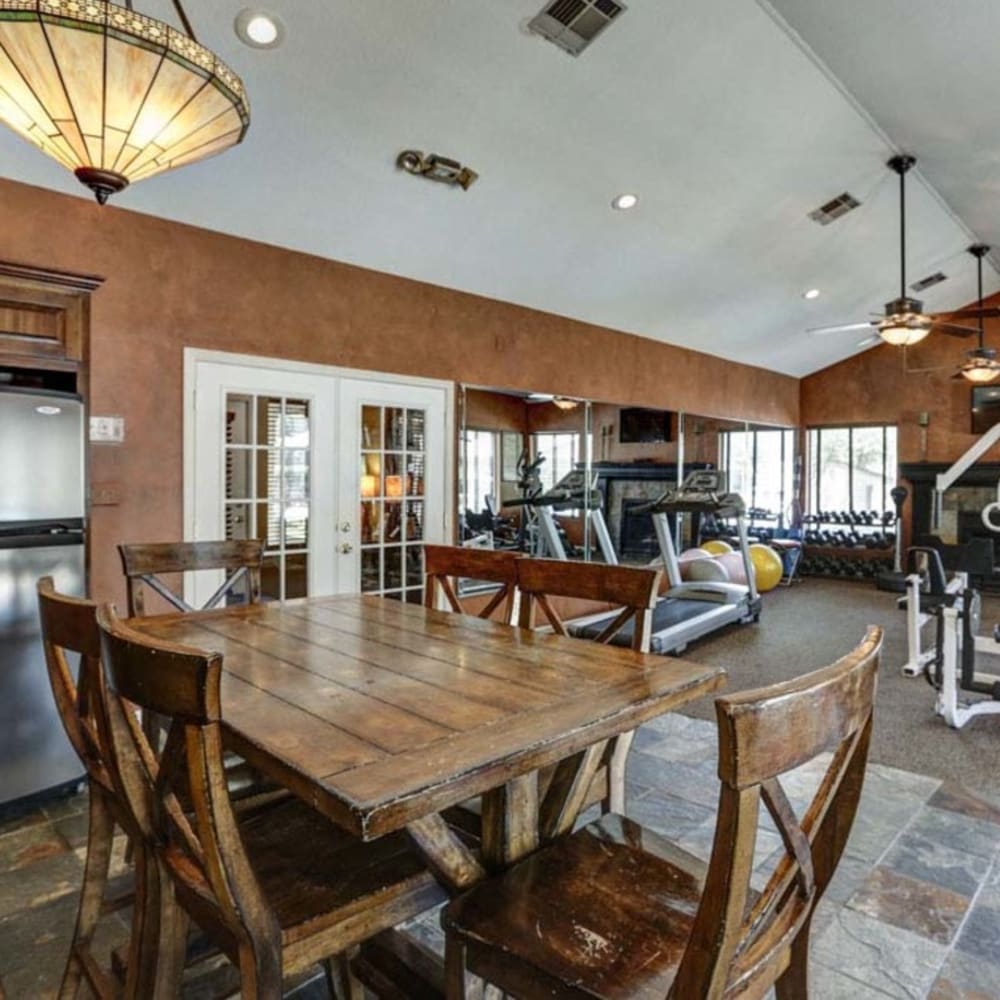 Resident clubhouse featuring gym and wood table seating at Springhill Apartments in Overland Park, Kansas