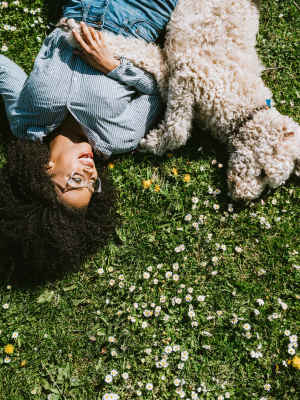 Resident and her dog laying in a field near The Jade at Avondale in Decatur, Georgia