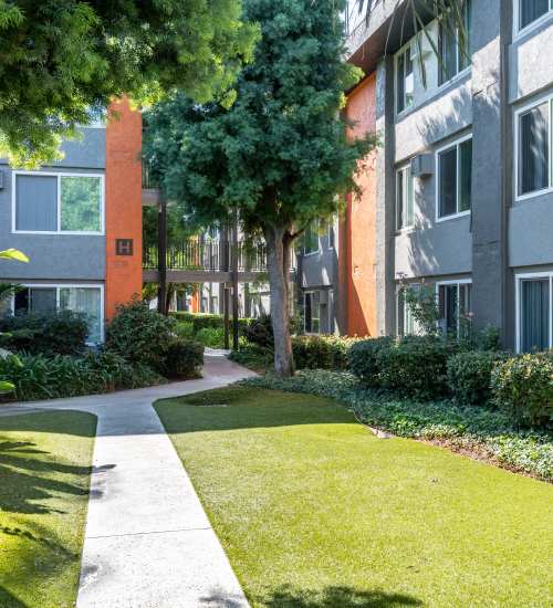 Building exterior with pathway at UCA Apartment Homes in Fullerton,California