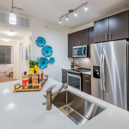 Kitchen and dining area of a modern apartment home at The Reverie at Lake Boone in Raleigh, North Carolina