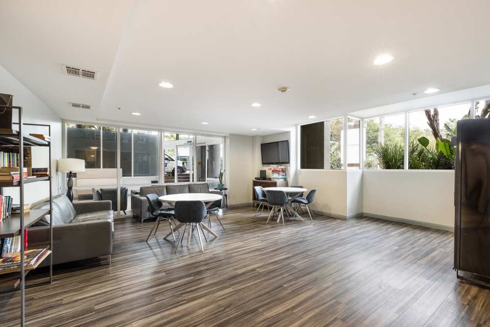 Luxury seating area with tables and bookshelves at Capri Apartments in Marina Del Rey, California