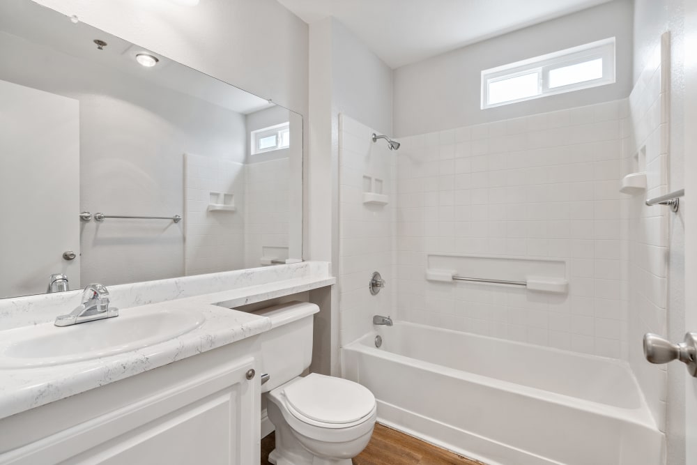 Bathroom with tub/shower and white cabinetry at Quail Hill Apartments in Castro Valley, California